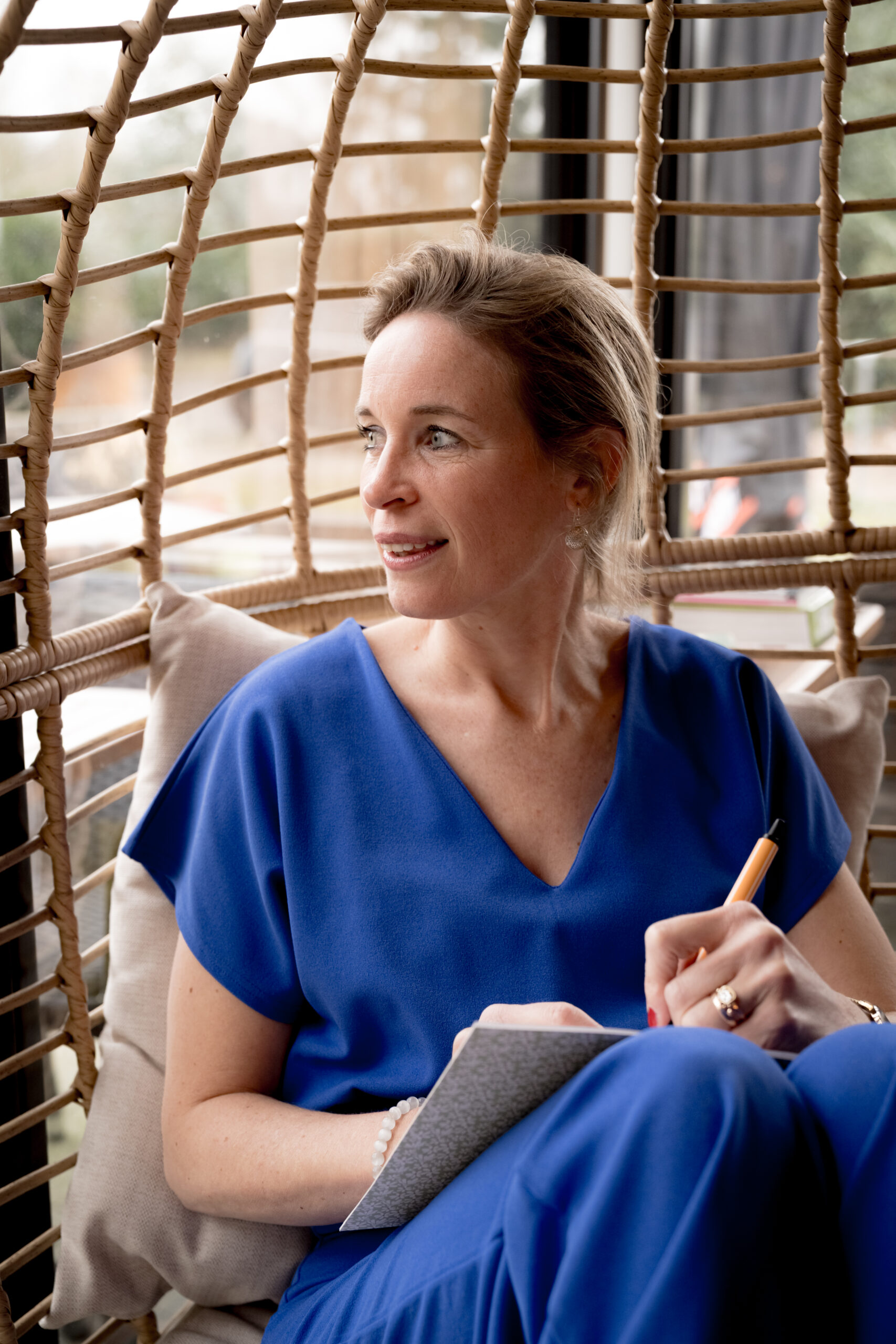 Nienke Nederveen in hangstoel, schrijvend in notitieboek